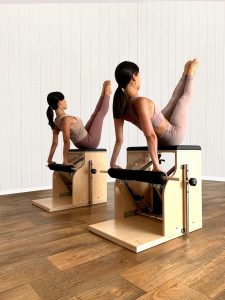 Due persone sui macchinari chair in studio di pilates a roma